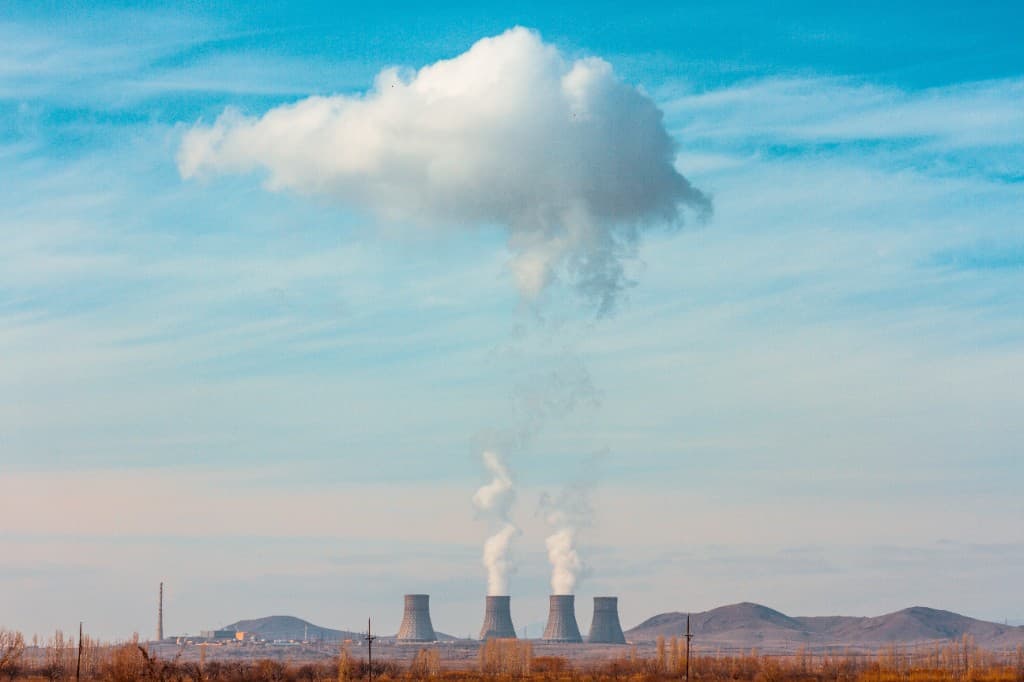 Nuclear power plant with cooling towers in a mountain landscape